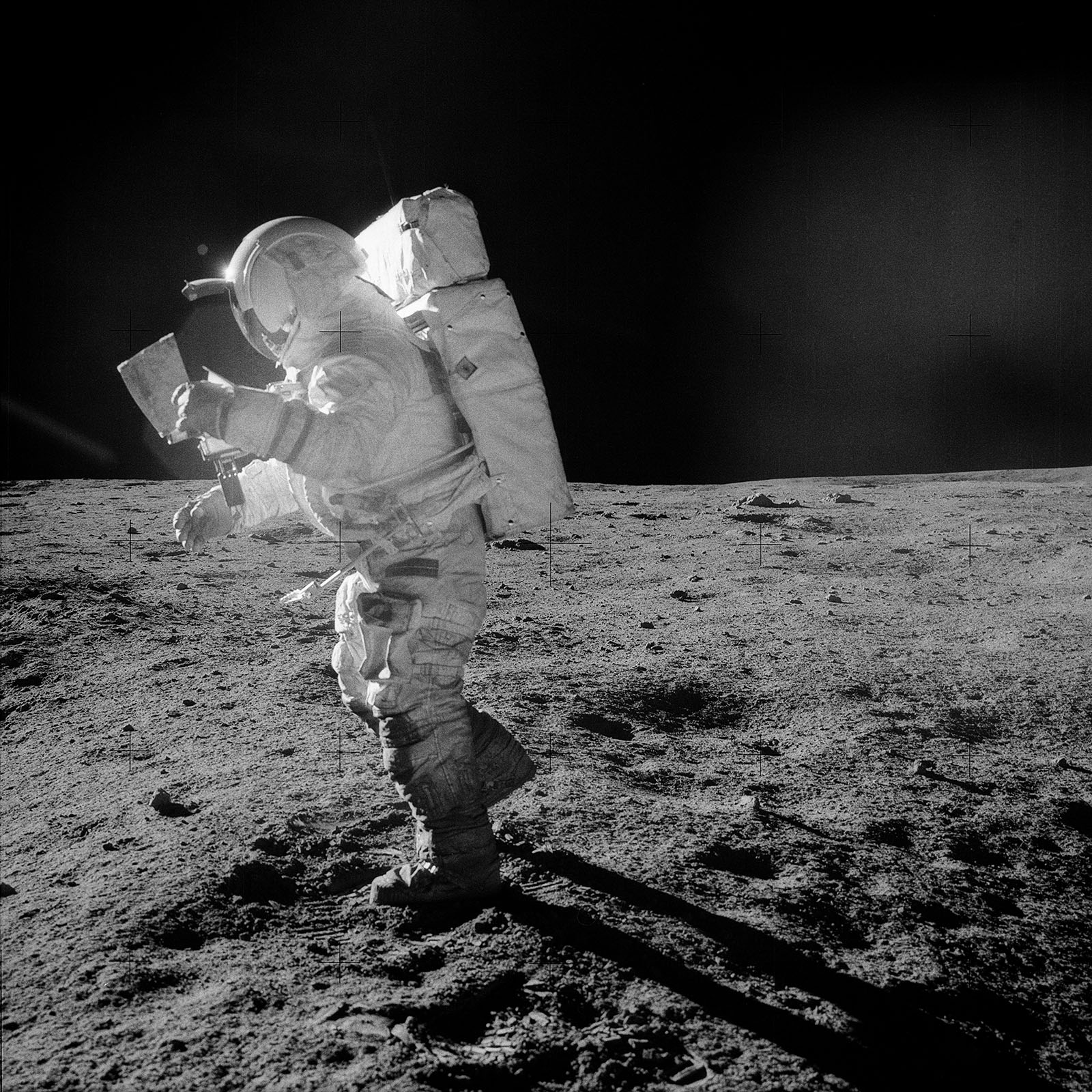 A photo of astronaut Mitchell looking at a map on his way to Cone crater