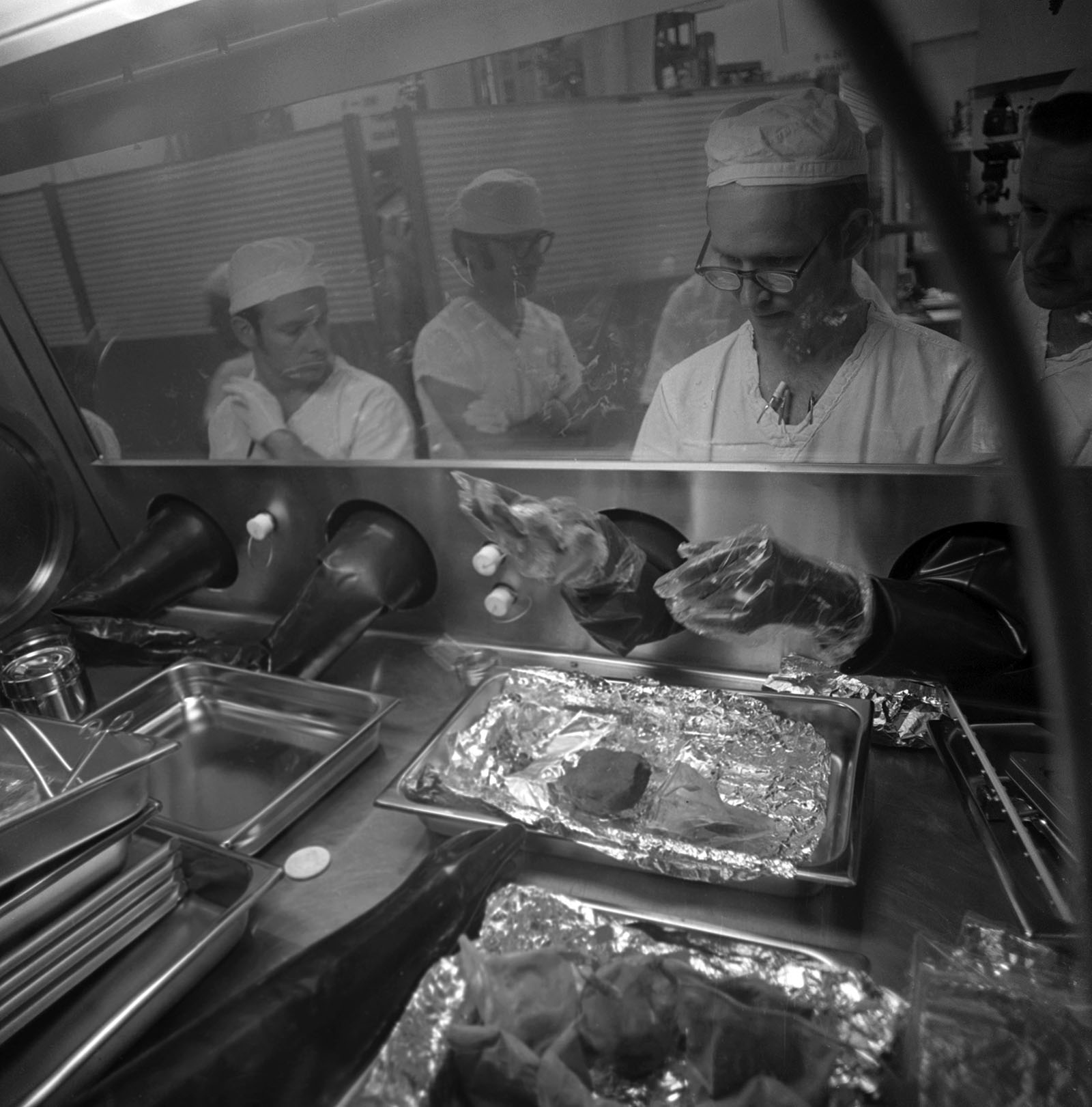 A photo of scientists examining samples brought from the Apollo 14 mission