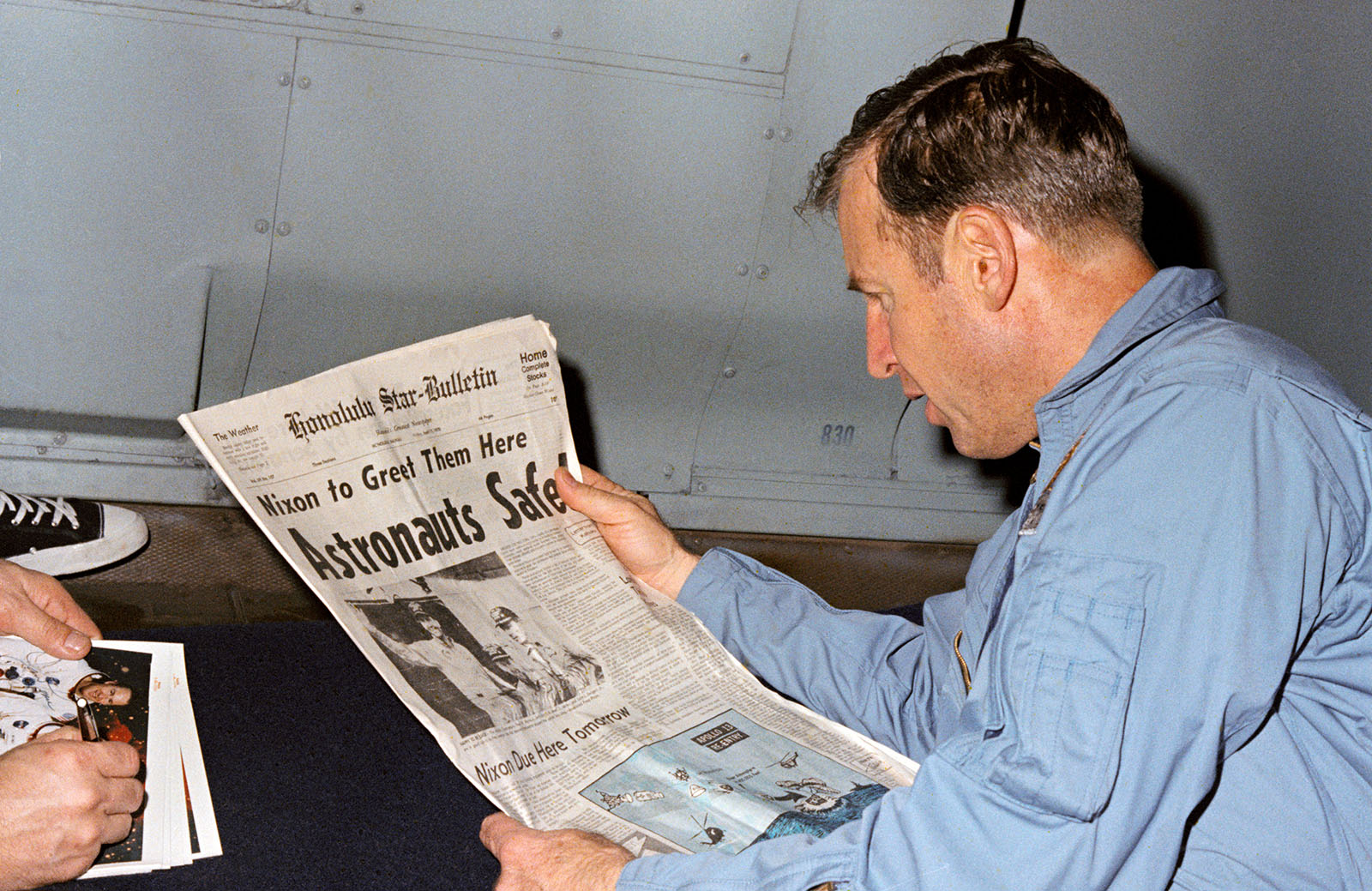 A photo of astronaut,Lovell reading the newspaper