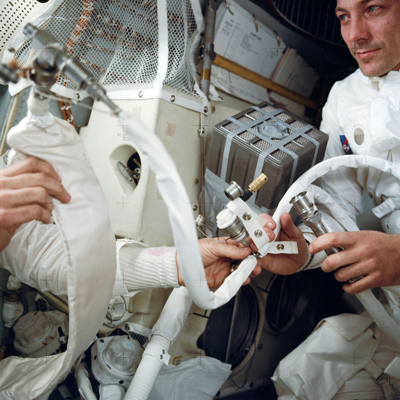 A photo of astronauts,Swigert and Haise,holding a hose