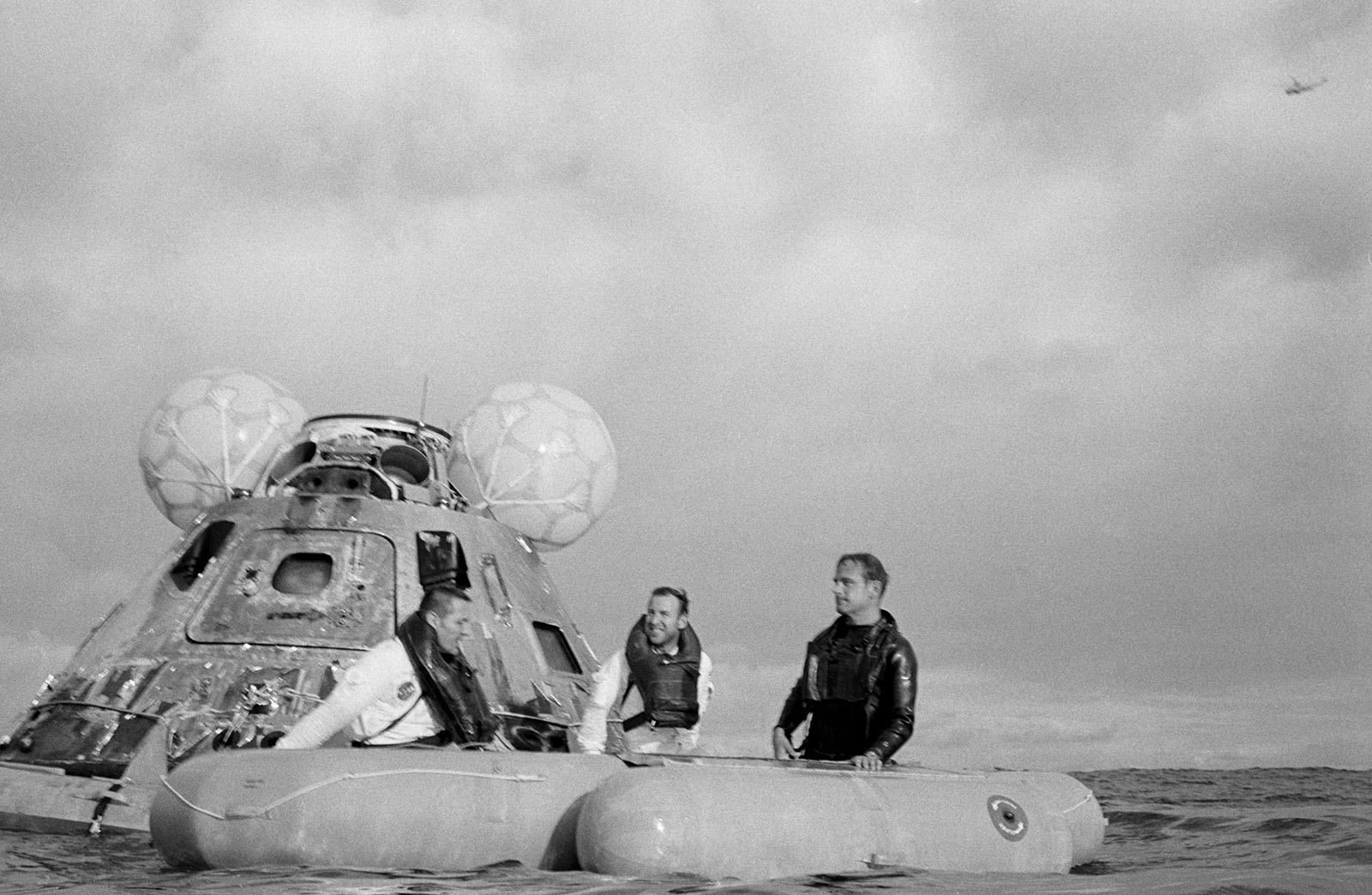 A photo of three astronauts on a life raft