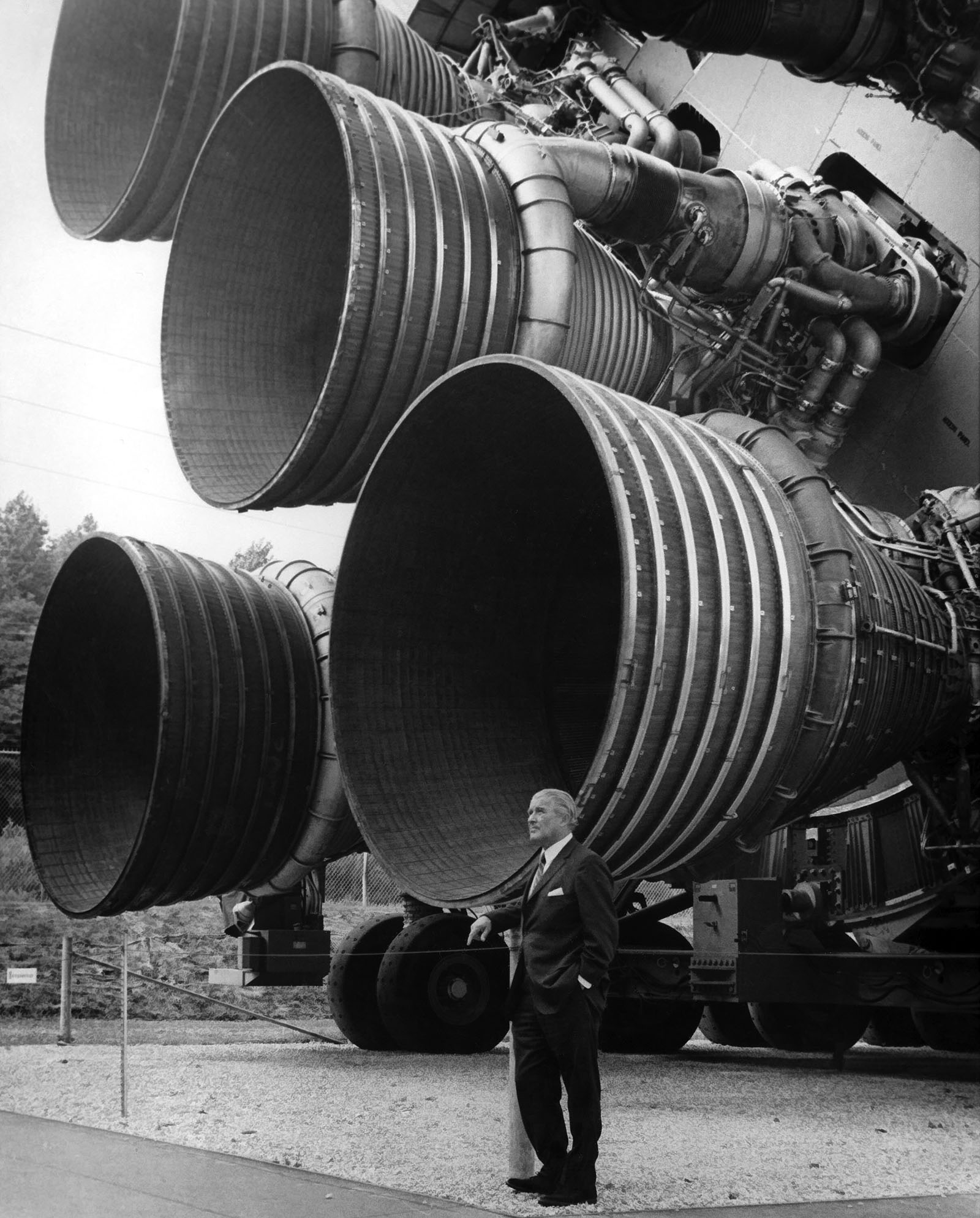 A photo of Dr. von Braun standing next to one of the five engines of Saturn V