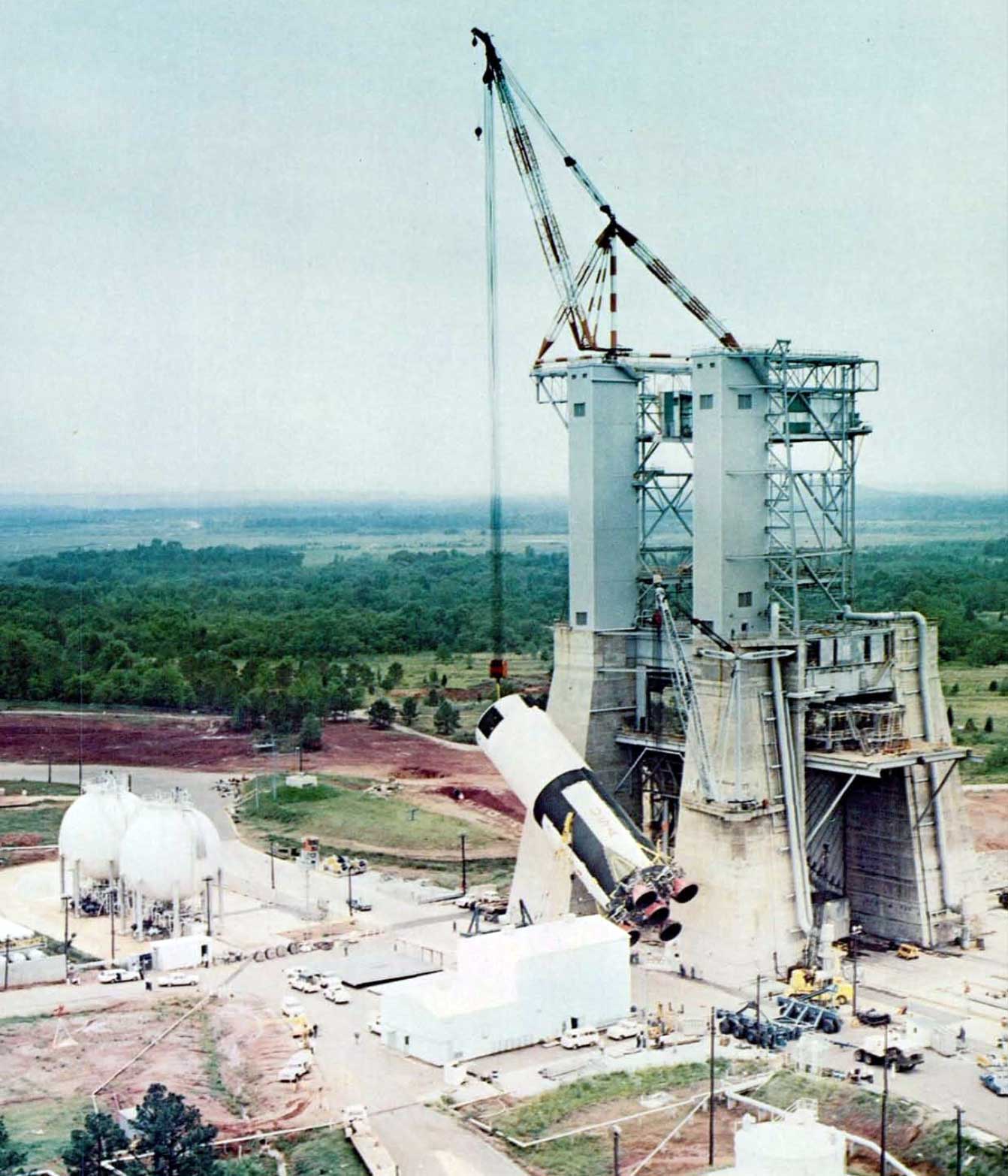 A photo of the S-IC stage being hoisted into the static test stand