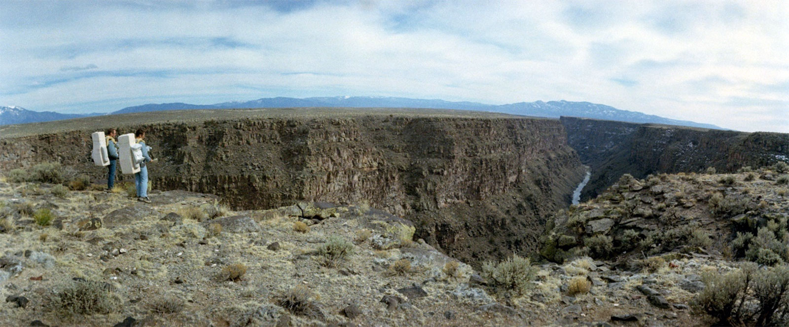 A photo of Apollo 15 astronauts,Irwin and Scott, standing at the rim of the Rio Grande gorge