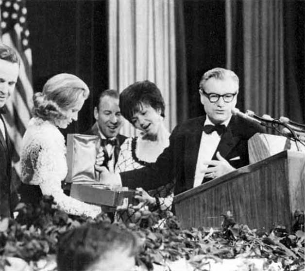 A photo of New York Governor Nelson Rockefeller presenting a commemorative plates to wives of astronauts