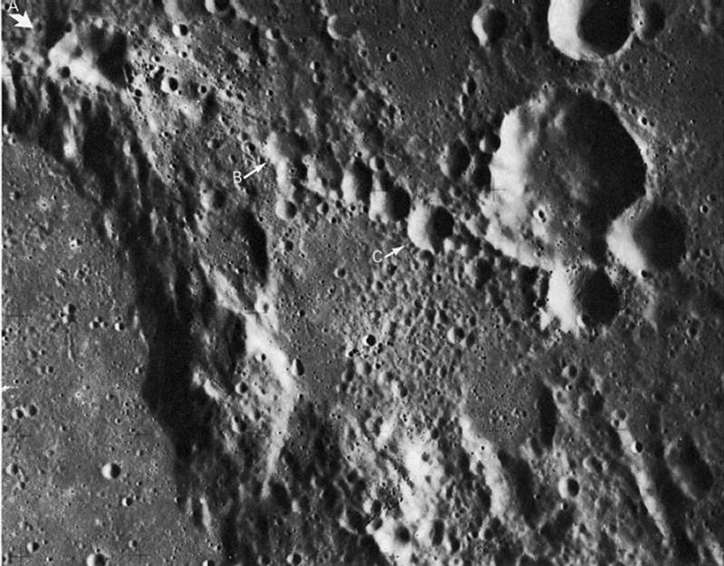 FIGURE 132. - The crater chain extending from the large arrow at A is part of a discontinuous lineament that grazes the northeast rim of Ptolemaeus (left), and that may extend as far as 720 km beyond the edge of the picture.