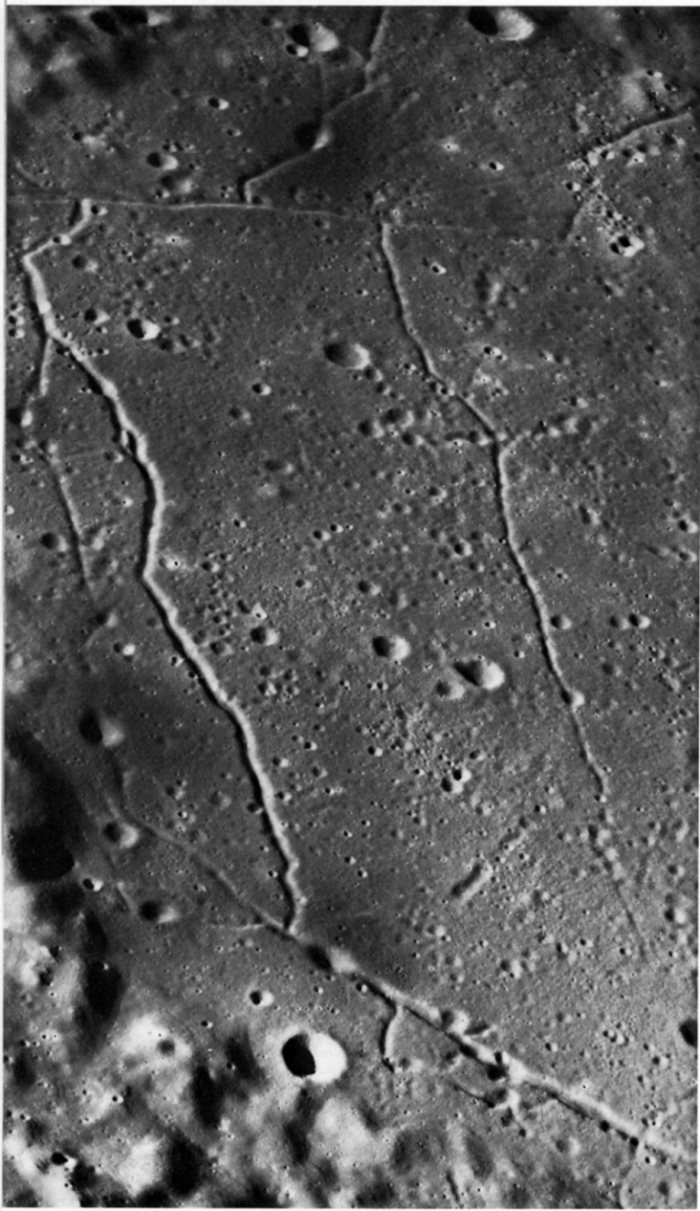 FIGURE 216. - This oblique view of part of the flat floor of the ancient crater Alphonsus shows faults that break the floor along straight line fractures.