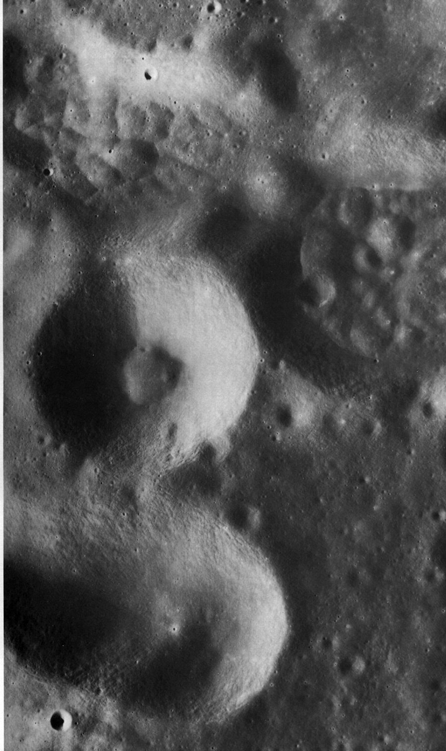 FIGURE 239. - The four large depressions in this photograph are part of a cluster of secondary impact craters on the floor of Gagarin, a large (275-km-diameter) crater on the far side of the Moon. 