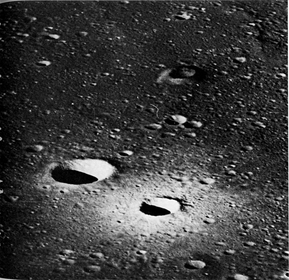 FIGURE 88. - This is an oblique view of an area in Mare Nubium west of the central lunar highlands taken with the Hasselblad camera on Apollo 16. The small picture to the left is the entire frame reproduced slightly larger (112 percent) than the size of the original negative, and the larger picture on the facing page is a 12.5X enlargement of the area outlined within the small picture.