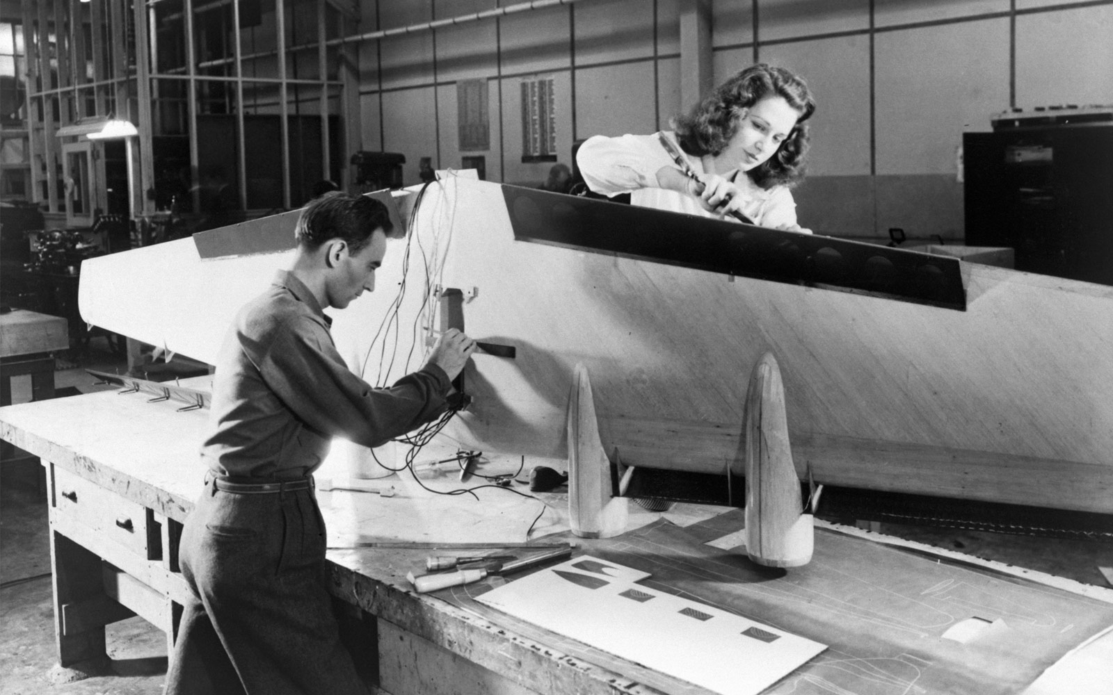 a man and woman are pictured measuring a wing