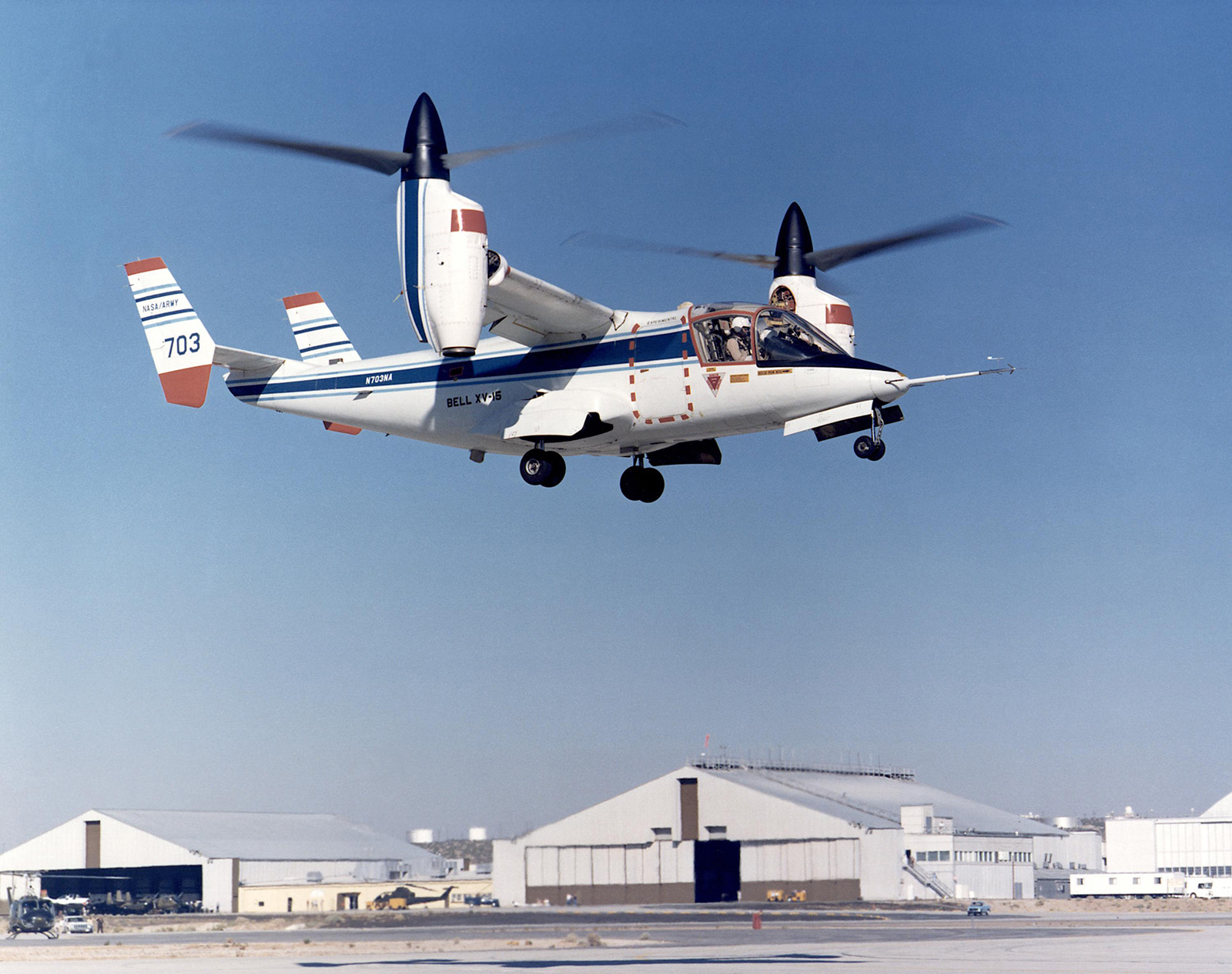 tilt rotor aircraft hoovering above airfield